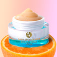Dark Spot Eraser Mask Jar by ANJALI MD Skincare. Sitting ontop of a sliced orange. Peach Gel Mask visible