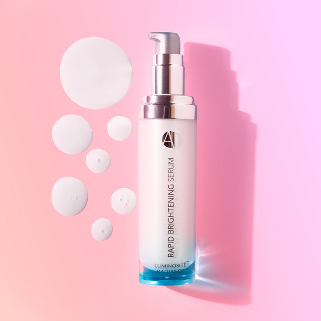 ANJALI MD Skincare Rapid Brightening Serum shown open with serum dots on a gradient pink background